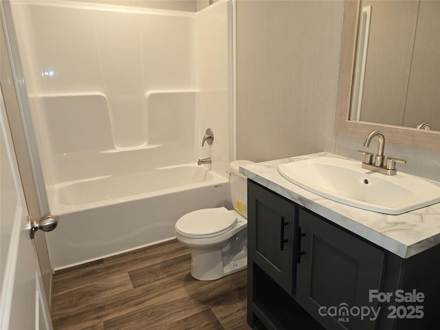 full bath with wood finished floors, toilet, vanity, and bathtub / shower combination