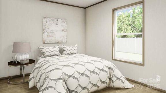 bedroom featuring wood finished floors and baseboards