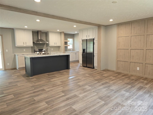 28 Mcgee Hill Rd, Fairview, NC 28730 - kitchen with appliances with stainless steel finishes, wall chimney range hood, a decorative wall, light countertops, and light wood finished floors