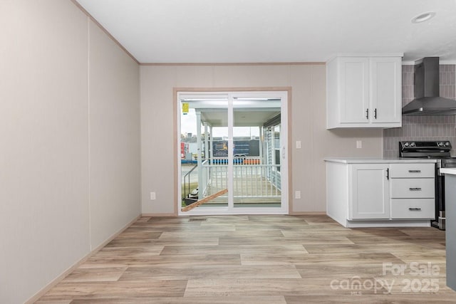 28 Mcgee Hill Rd, Fairview, NC 28730 - kitchen featuring wall chimney exhaust hood, stainless steel range with electric stovetop, light wood-style floors, white cabinets, and light countertops