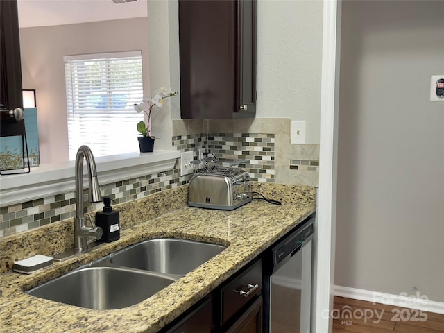 218 Cottonwood Park Dr, Charlotte, NC 28214 - kitchen featuring light stone counters, a sink, dark brown cabinets, dishwasher, and tasteful backsplash