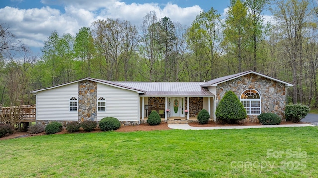 ranch-style home featuring a porch, metal roof, a front yard, and stone siding