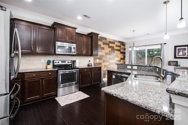 128 Millen Dr, Mooresville, NC 28115 - kitchen with appliances with stainless steel finishes, crown molding, dark brown cabinets, dark wood-style flooring, and hanging light fixtures
