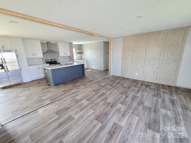 22 Mcgee Hill Rd, Fairview, NC 28730 - kitchen with stainless steel appliances, wall chimney exhaust hood, light wood-type flooring, light countertops, and a textured ceiling