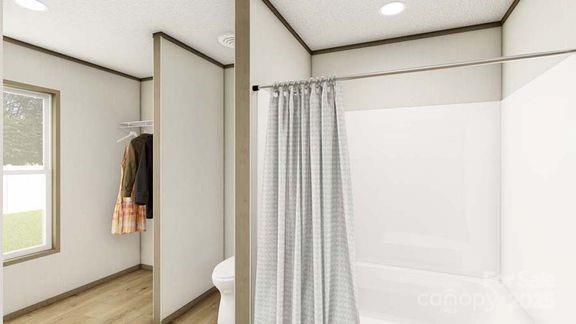 22 Mcgee Hill Rd, Fairview, NC 28730 - full bath with wood finished floors, a shower with shower curtain, a textured ceiling, and a closet