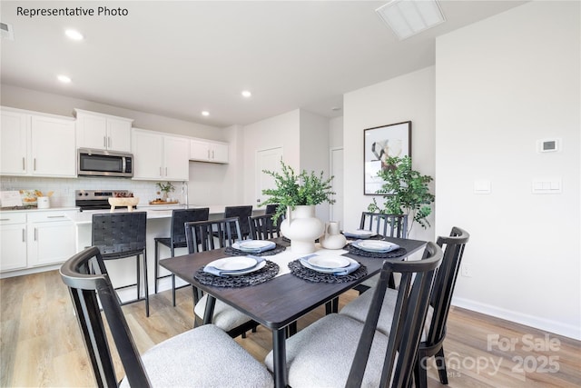 dining room featuring recessed lighting, visible vents, and light wood-type flooring