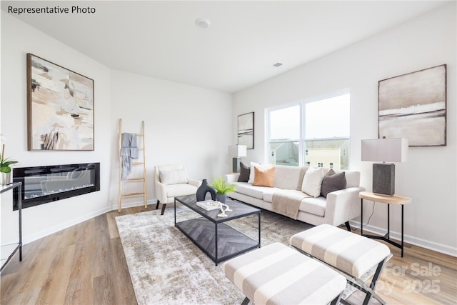 living room featuring baseboards, wood finished floors, and visible vents