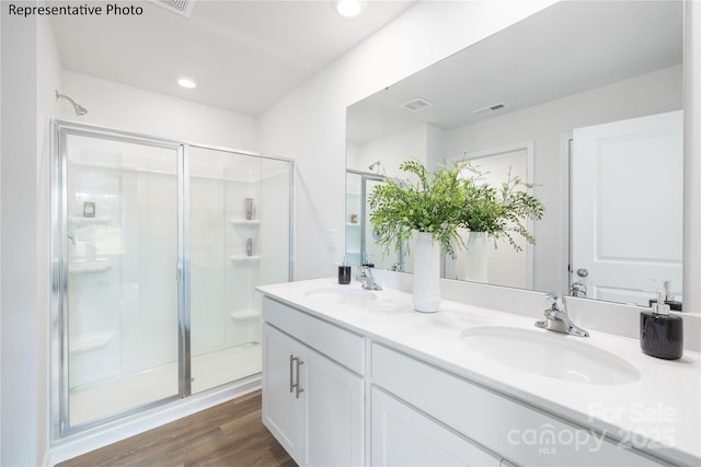 bathroom with visible vents, a stall shower, and a sink