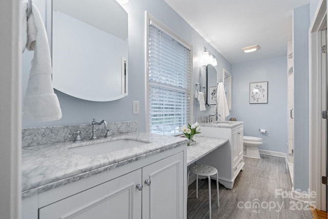 3808 Severn Ave, Charlotte, NC 28210 - full bathroom with baseboards, toilet, a sink, and two vanities