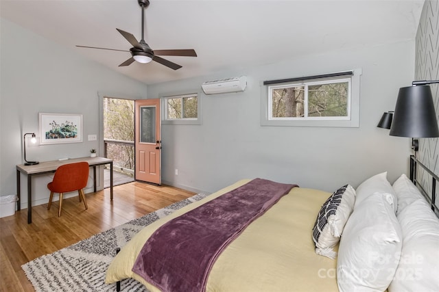 bedroom featuring baseboards, a wall mounted air conditioner, ceiling fan, vaulted ceiling, and wood finished floors