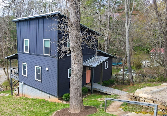 view of side of home with board and batten siding and a trampoline