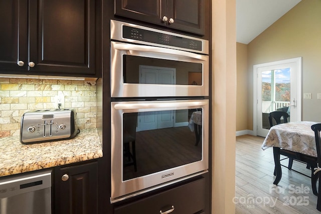 226 Hermance Ln, Mooresville, NC 28117 - kitchen featuring stainless steel appliances, decorative backsplash, light wood-style floors, lofted ceiling, and dark brown cabinetry