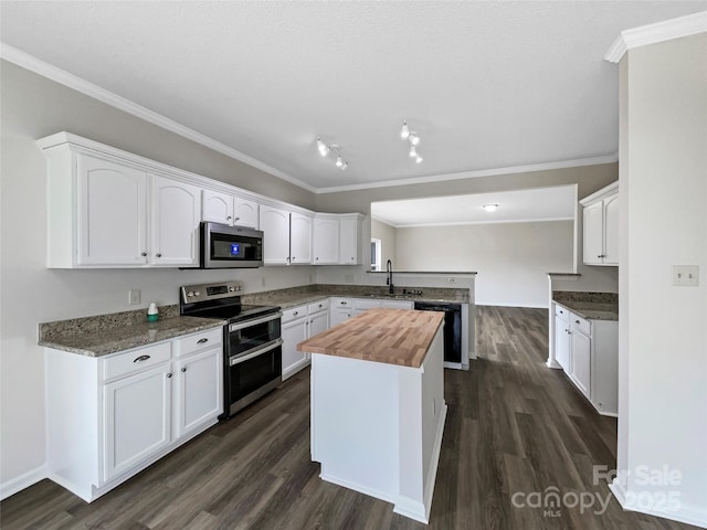 kitchen featuring dark wood finished floors, butcher block countertops, white cabinetry, and stainless steel appliances