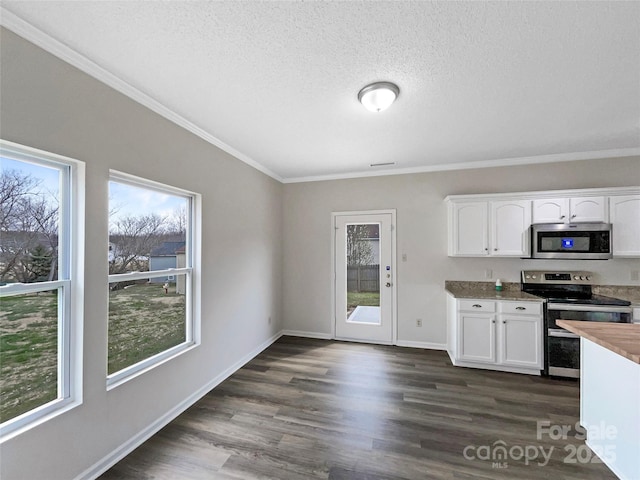 kitchen featuring dark wood-type flooring, white cabinets, appliances with stainless steel finishes, and ornamental molding