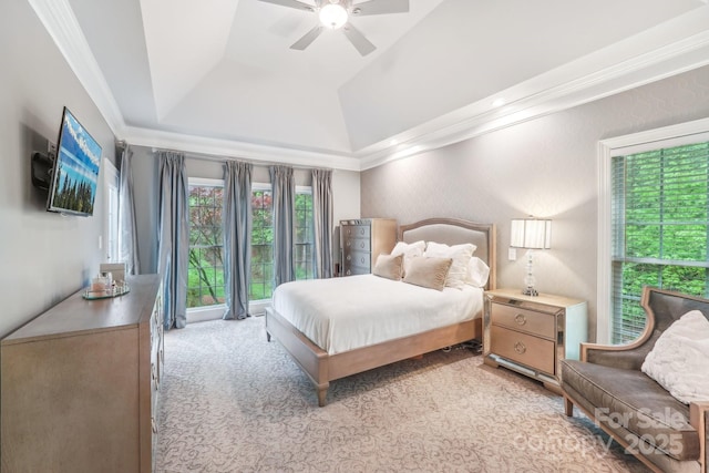 bedroom with lofted ceiling, light carpet, crown molding, a ceiling fan, and a raised ceiling