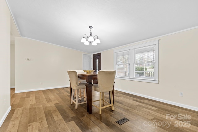 117 Pine Bluff Dr, Mooresville, NC 28117 - dining room with visible vents, baseboards, a chandelier, ornamental molding, and wood finished floors