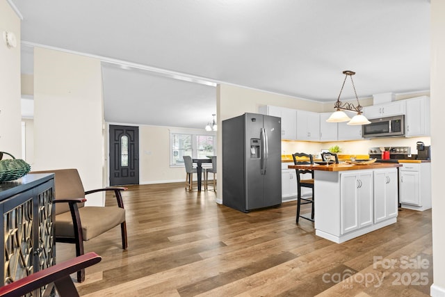 117 Pine Bluff Dr, Mooresville, NC 28117 - kitchen with a breakfast bar, wood finished floors, white cabinetry, appliances with stainless steel finishes, and wooden counters
