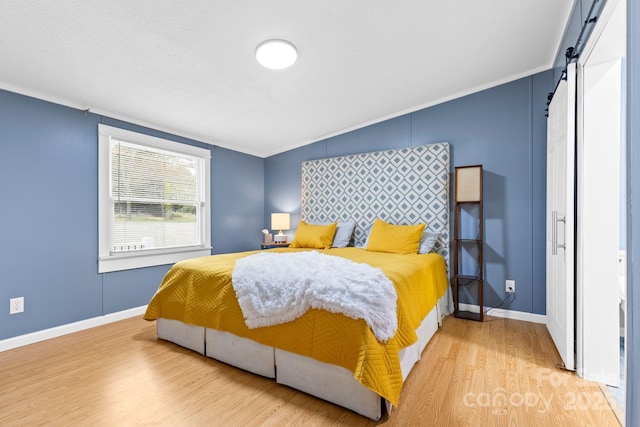 117 Pine Bluff Dr, Mooresville, NC 28117 - bedroom with baseboards, a barn door, and wood finished floors