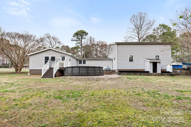 117 Pine Bluff Dr, Mooresville, NC 28117 - back of house featuring a yard, a swimming pool, and a deck
