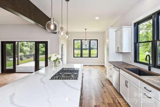 kitchen with plenty of natural light, a sink, appliances with stainless steel finishes, and white cabinets
