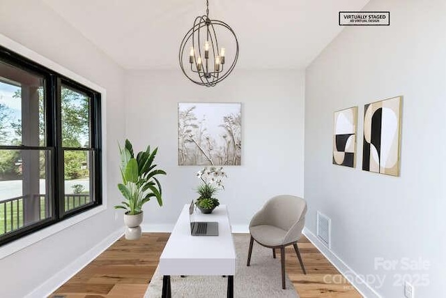 sitting room with baseboards, an inviting chandelier, wood finished floors, and visible vents