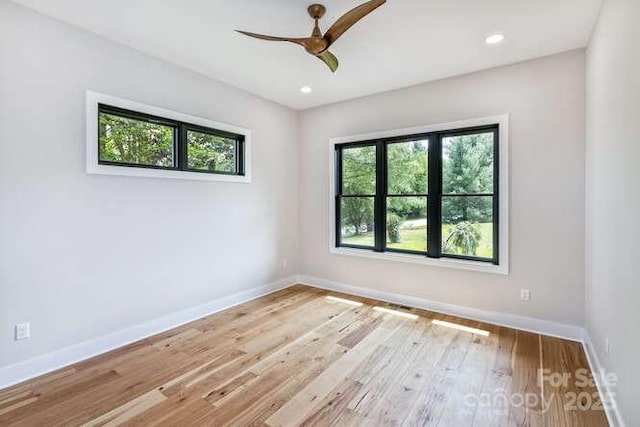 unfurnished room featuring a healthy amount of sunlight, baseboards, ceiling fan, and wood finished floors