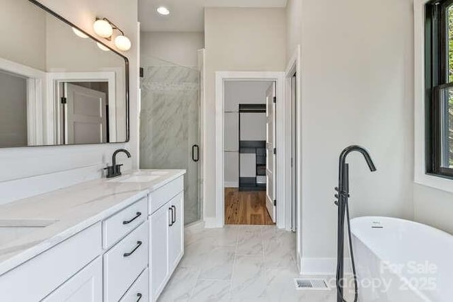 full bath featuring a sink, marble finish floor, baseboards, a shower stall, and a soaking tub