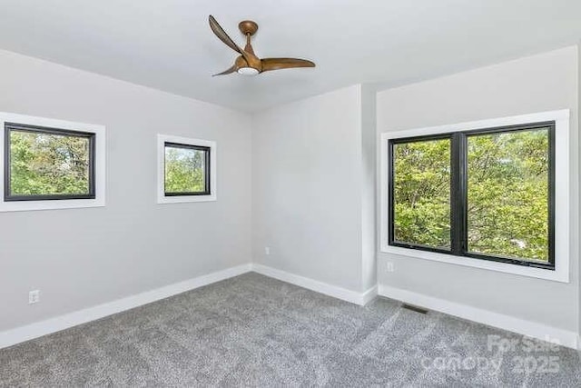 spare room with carpet floors, a ceiling fan, and baseboards
