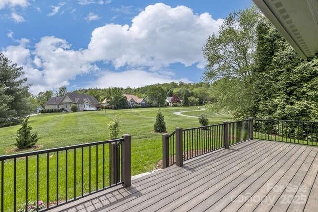 wooden deck featuring a lawn