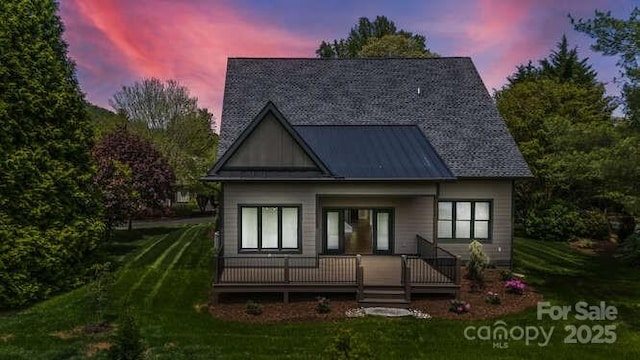 view of front of house featuring a standing seam roof, metal roof, and a front yard