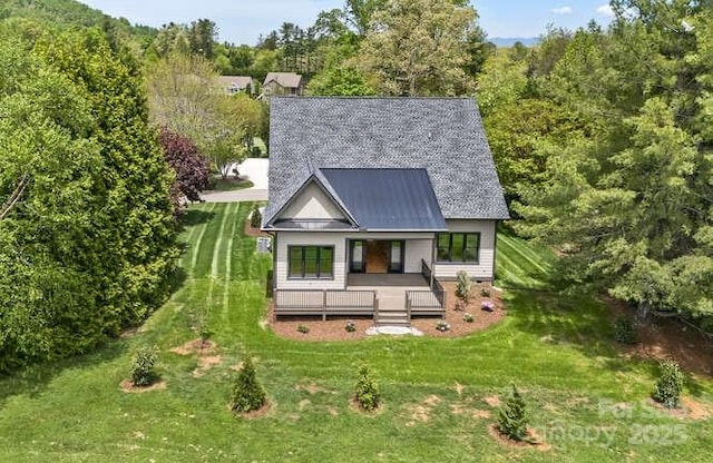 exterior space with a porch, a view of trees, and a front yard