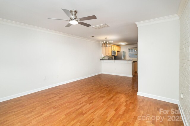 unfurnished living room with light wood-style floors, ornamental molding, ceiling fan with notable chandelier, baseboards, and visible vents