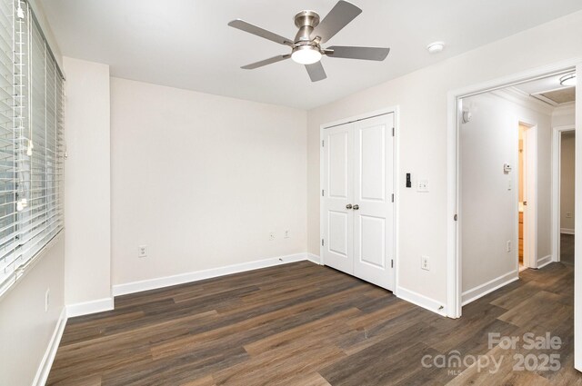 unfurnished bedroom with wood finished floors, a closet, a ceiling fan, and baseboards