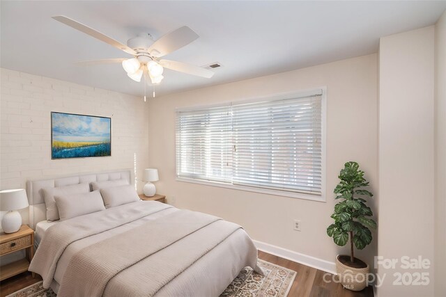 bedroom featuring baseboards, visible vents, wood finished floors, and ceiling fan