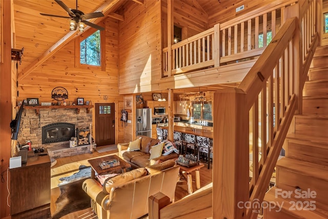 1600 Pisgah Preserve Dr, Nebo, NC 28761 - living area featuring high vaulted ceiling, stairway, a ceiling fan, wooden walls, and wood finished floors