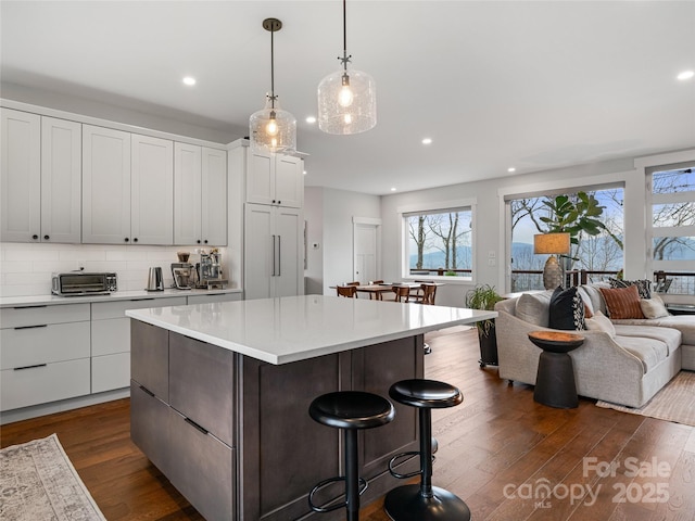 322 Windswept Dr, Asheville, NC 28801 - kitchen with light countertops, a kitchen breakfast bar, dark wood-style floors, and a healthy amount of sunlight