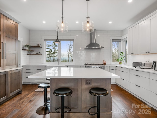 322 Windswept Dr, Asheville, NC 28801 - kitchen with wall chimney range hood, a center island, a breakfast bar area, and backsplash