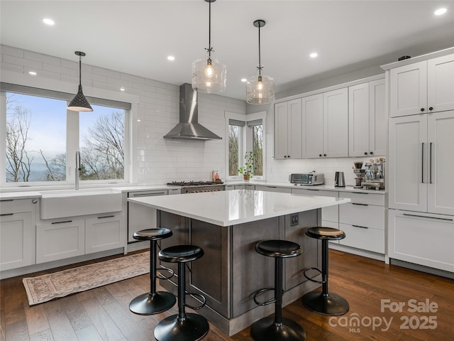322 Windswept Dr, Asheville, NC 28801 - kitchen featuring a kitchen breakfast bar, a center island, wall chimney exhaust hood, tasteful backsplash, and a sink