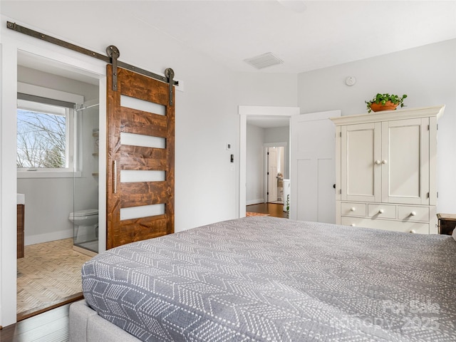 322 Windswept Dr, Asheville, NC 28801 - bedroom featuring visible vents, a barn door, wood finished floors, baseboards, and connected bathroom