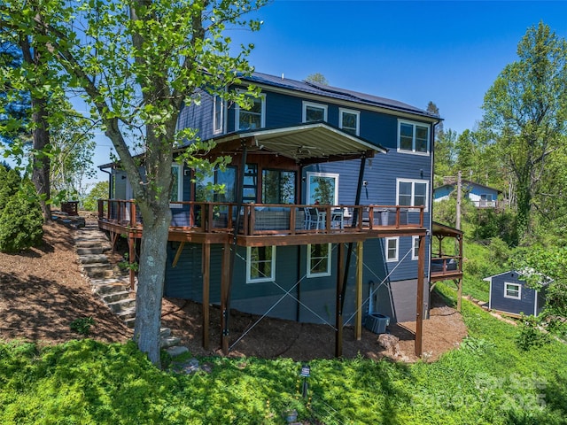 322 Windswept Dr, Asheville, NC 28801 - rear view of house featuring central air condition unit, a wooden deck, an outbuilding, and a storage shed