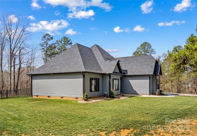 view of front facade with a front yard, fence, roof with shingles, and crawl space