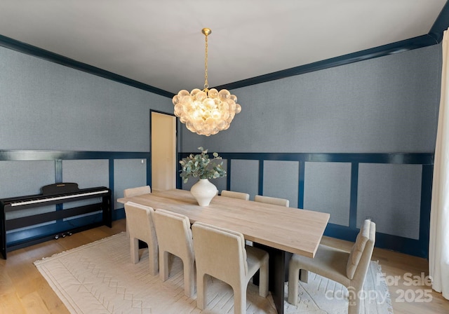 300 Mammoth Oaks Dr, Charlotte, NC 28270 - dining space with crown molding, a chandelier, a decorative wall, wood finished floors, and a wainscoted wall