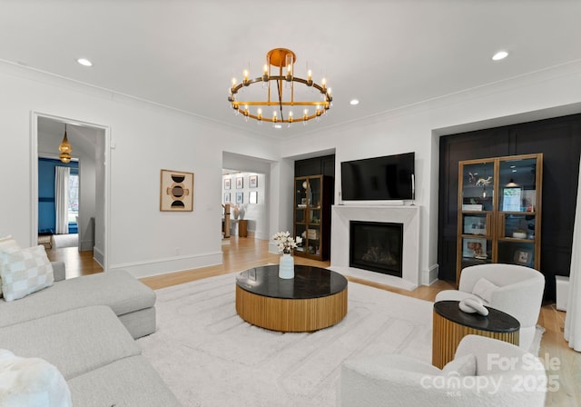 300 Mammoth Oaks Dr, Charlotte, NC 28270 - living room featuring a chandelier, light wood-type flooring, ornamental molding, a fireplace with raised hearth, and baseboards