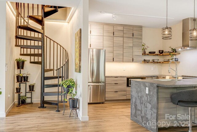 47 Webb Cove Rd, Asheville, NC 28804 - kitchen with light wood-type flooring, a kitchen breakfast bar, freestanding refrigerator, modern cabinets, and a sink