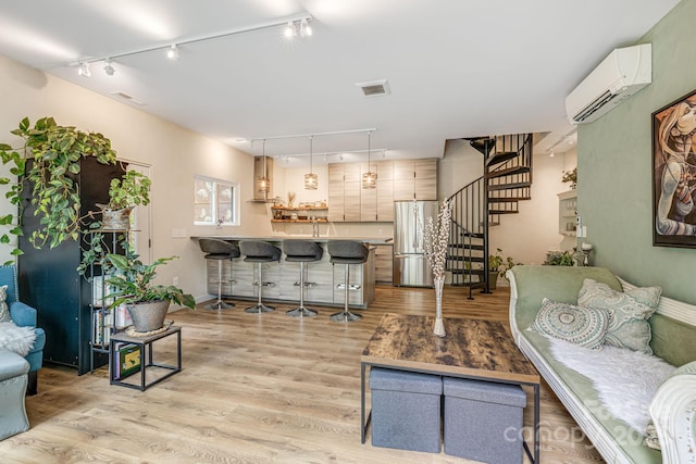 47 Webb Cove Rd, Asheville, NC 28804 - living room featuring a wall mounted air conditioner, visible vents, light wood-style flooring, rail lighting, and stairs