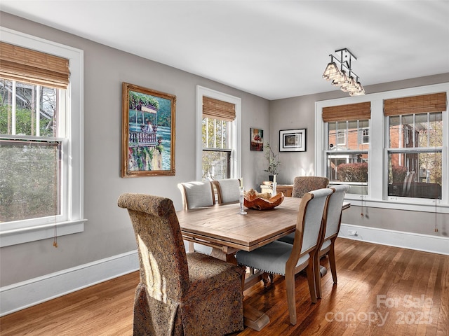 dining space featuring wood finished floors and baseboards