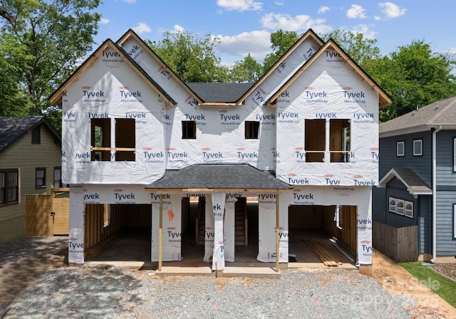 property in mid-construction featuring a garage and a shingled roof