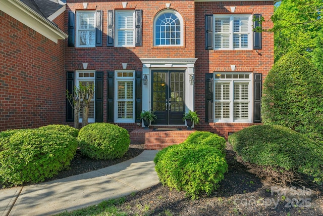 entrance to property with brick siding and french doors