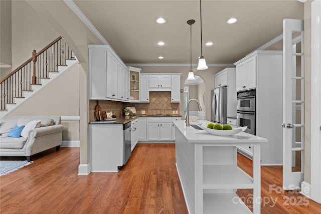 kitchen featuring decorative backsplash, ornamental molding, stainless steel appliances, and recessed lighting