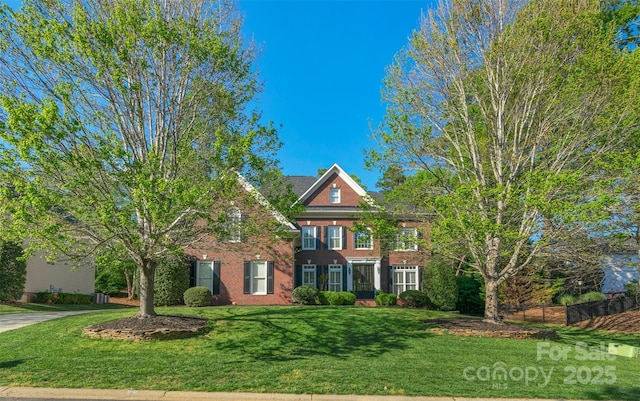 georgian-style home with a front lawn and brick siding